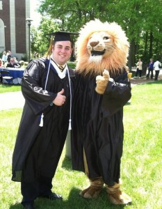 graduating student posing with tcnj lion