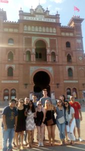 group posing in front of tall building