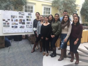 group posing next to poster